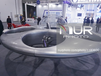 Visitors look at a manned flying saucer electric vertical take-off and landing (eVTOL) at the Zhejiang International Intelligent Transportat...