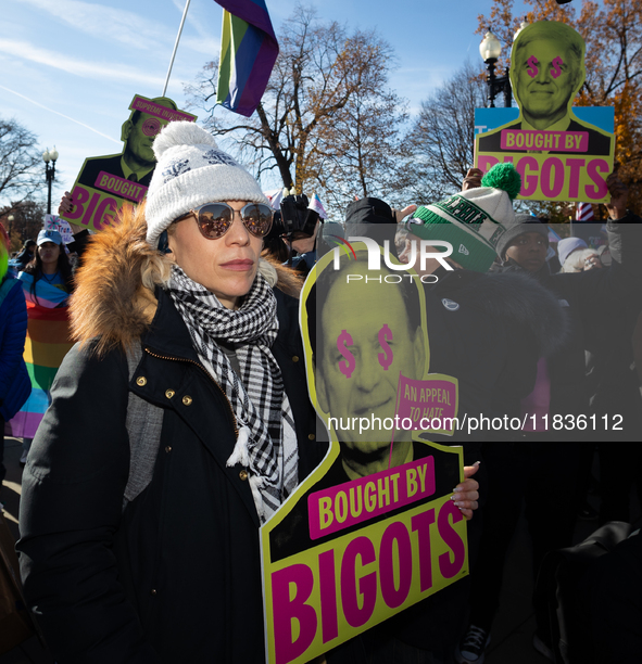 Demonstrators displays signs accusing Supreme Court Justices Samuel Alito and Neil Gorsuch, as well as Chief Justice John Roberts of corrupt...