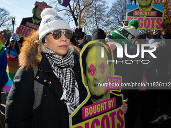 Demonstrators displays signs accusing Supreme Court Justices Samuel Alito and Neil Gorsuch, as well as Chief Justice John Roberts of corrupt...