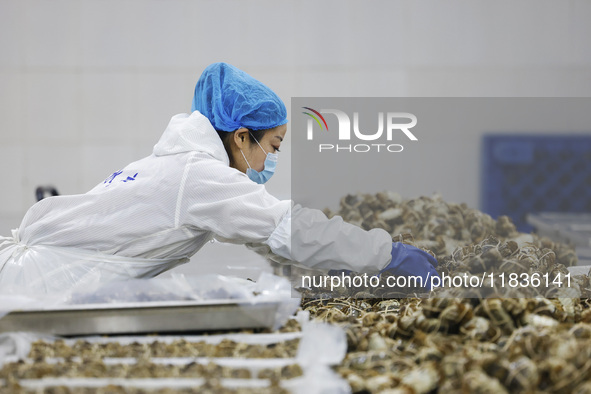 A worker processes crabs for export to South Korea at a production workshop of an aquatic food company in Suqian, Jiangsu province, China, o...