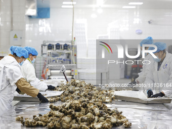 Workers process crabs for export to South Korea at a production workshop of an aquatic food company in Suqian, Jiangsu province, China, on D...