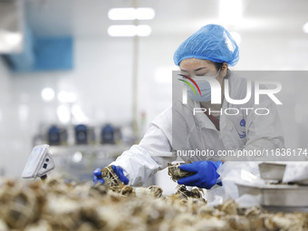 A worker processes crabs for export to South Korea at a production workshop of an aquatic food company in Suqian, Jiangsu province, China, o...