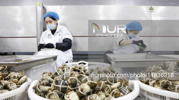 Workers process crabs for export to South Korea at a production workshop of an aquatic food company in Suqian, Jiangsu province, China, on D...