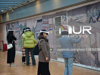 Visitors wear MR Glasses during an immersive interactive exhibition at the Capital Museum in Beijing, China, on December 5, 2024. (