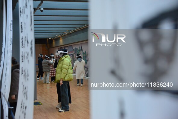 Visitors wear MR Glasses during an immersive interactive exhibition at the Capital Museum in Beijing, China, on December 5, 2024. 