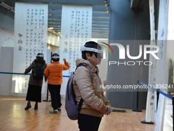 Visitors wear MR Glasses during an immersive interactive exhibition at the Capital Museum in Beijing, China, on December 5, 2024. (