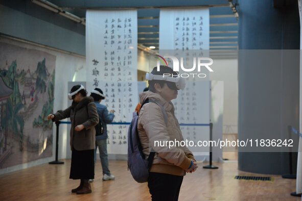 Visitors wear MR Glasses during an immersive interactive exhibition at the Capital Museum in Beijing, China, on December 5, 2024. 