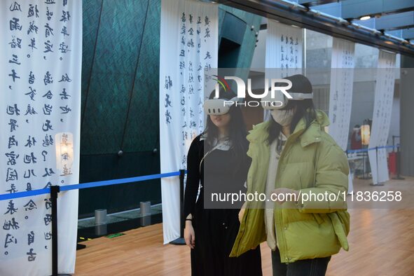 Visitors wear MR Glasses during an immersive interactive exhibition at the Capital Museum in Beijing, China, on December 5, 2024. 