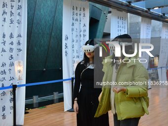 Visitors wear MR Glasses during an immersive interactive exhibition at the Capital Museum in Beijing, China, on December 5, 2024. (