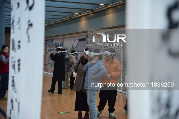 Visitors wear MR Glasses during an immersive interactive exhibition at the Capital Museum in Beijing, China, on December 5, 2024. 