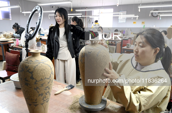 A staff member of a ceramic company helps job seekers understand the working environment of the company through a webcast in Handan, China,...