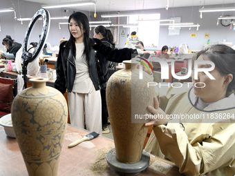 A staff member of a ceramic company helps job seekers understand the working environment of the company through a webcast in Handan, China,...