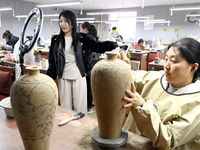 A staff member of a ceramic company helps job seekers understand the working environment of the company through a webcast in Handan, China,...