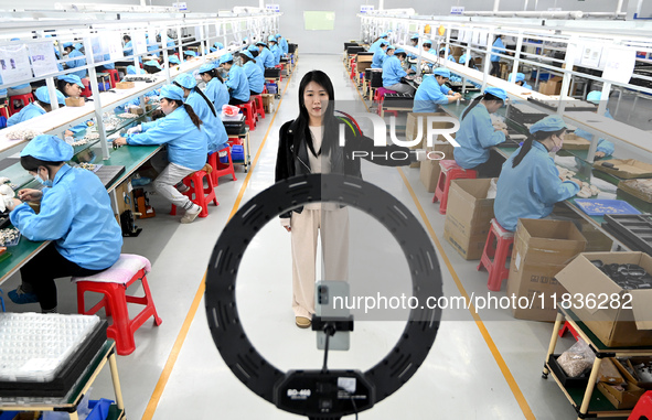 A staff member of an electronics company helps job seekers understand the working environment of the company through a webcast in Handan, Ch...