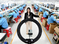 A staff member of an electronics company helps job seekers understand the working environment of the company through a webcast in Handan, Ch...