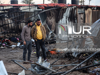 Palestinians inspect the damage in the aftermath of an Israeli strike on a tent camp in Khan Younis, Gaza Strip, on December 5, 2024, amid t...