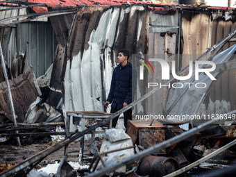 A Palestinian man inspects the damage in the aftermath of an Israeli strike on a tent camp in Khan Younis, Gaza Strip, on December 5, 2024,...