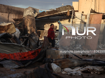 Palestinians inspect the damage in the aftermath of an Israeli strike on a tent camp in Khan Younis, Gaza Strip, on December 5, 2024, amid t...