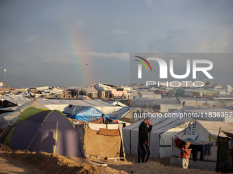 A rainbow appears over a makeshift camp in Khan Younis, Gaza Strip, on December 5, 2024, amid the ongoing war between Israel and Hamas milit...