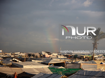 A rainbow appears over a makeshift camp in Khan Younis, Gaza Strip, on December 5, 2024, amid the ongoing war between Israel and Hamas milit...