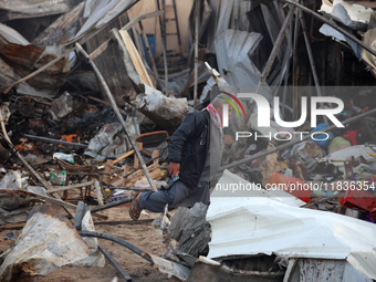 A Palestinian man inspects the damage in the aftermath of an Israeli strike on a tent camp in Khan Younis, Gaza Strip, on December 5, 2024,...