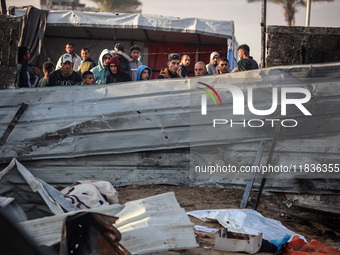 Palestinians inspect the damage in the aftermath of an Israeli strike on a tent camp in Khan Younis, Gaza Strip, on December 5, 2024, amid t...