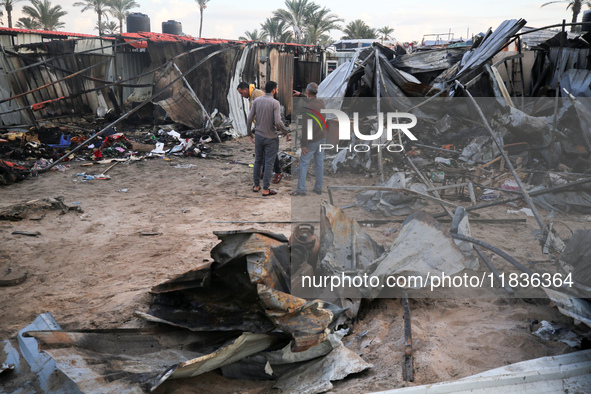 Palestinians inspect the damage in the aftermath of an Israeli strike on a tent camp in Khan Younis, Gaza Strip, on December 5, 2024, amid t...