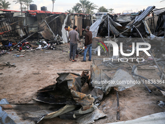 Palestinians inspect the damage in the aftermath of an Israeli strike on a tent camp in Khan Younis, Gaza Strip, on December 5, 2024, amid t...