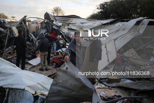 Palestinians inspect the damage in the aftermath of an Israeli strike on a tent camp in Khan Younis, Gaza Strip, on December 5, 2024, amid t...