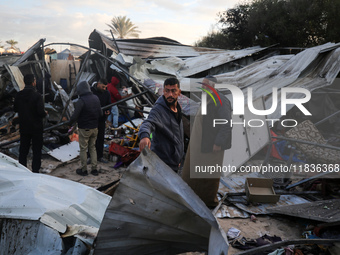 Palestinians inspect the damage in the aftermath of an Israeli strike on a tent camp in Khan Younis, Gaza Strip, on December 5, 2024, amid t...