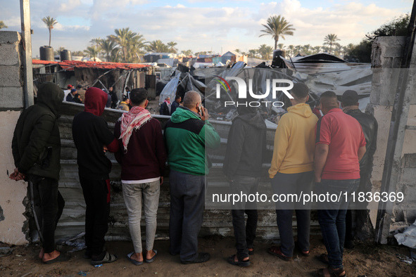 Palestinians inspect the damage in the aftermath of an Israeli strike on a tent camp in Khan Younis, Gaza Strip, on December 5, 2024, amid t...