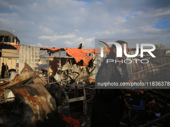 Palestinians inspect the damage in the aftermath of an Israeli strike on a tent camp in Khan Younis, Gaza Strip, on December 5, 2024, amid t...