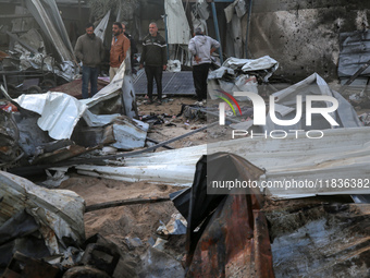 Palestinians inspect the damage in the aftermath of an Israeli strike on a tent camp in Khan Younis, Gaza Strip, on December 5, 2024, amid t...