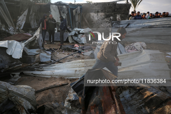 Palestinians inspect the damage in the aftermath of an Israeli strike on a tent camp in Khan Younis, Gaza Strip, on December 5, 2024, amid t...