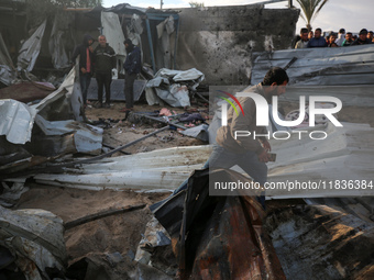 Palestinians inspect the damage in the aftermath of an Israeli strike on a tent camp in Khan Younis, Gaza Strip, on December 5, 2024, amid t...