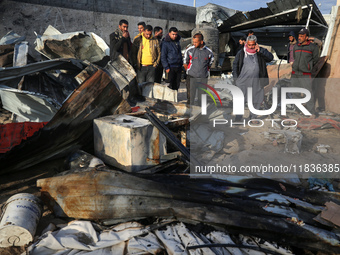 Palestinians inspect the damage in the aftermath of an Israeli strike on a tent camp in Khan Younis, Gaza Strip, on December 5, 2024, amid t...