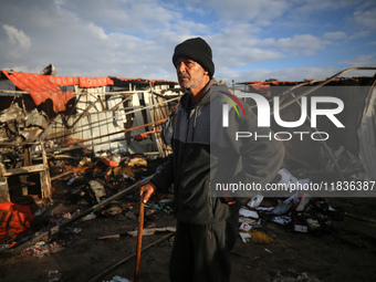 A Palestinian man inspects the damage in the aftermath of an Israeli strike on a tent camp in Khan Younis, Gaza Strip, on December 5, 2024,...