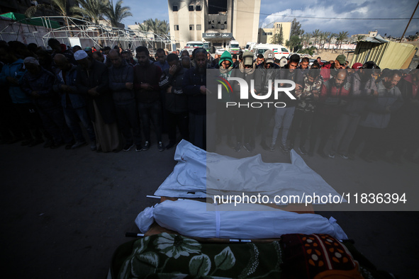 People gather near the body of a Palestinian killed in an Israeli strike at Nasser hospital in Khan Younis, Gaza Strip, on December 5, 2024....