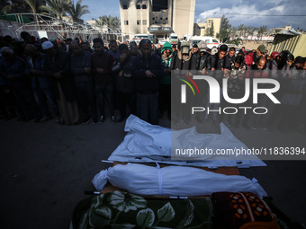 People gather near the body of a Palestinian killed in an Israeli strike at Nasser hospital in Khan Younis, Gaza Strip, on December 5, 2024....