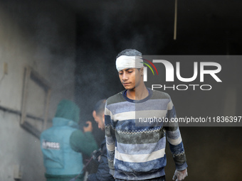 People stand on the rubble of a building after an Israeli strike in Nuseirat, Gaza Strip, on December 5, 2024, as the war between Israel and...