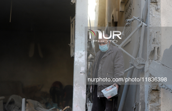 People stand on the rubble of a building after an Israeli strike in Nuseirat, Gaza Strip, on December 5, 2024, as the war between Israel and...