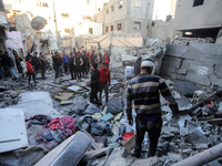 People stand on the rubble of a building after an Israeli strike in Nuseirat, Gaza Strip, on December 5, 2024, as the war between Israel and...