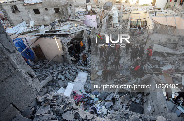 People stand on the rubble of a building after an Israeli strike in Nuseirat, Gaza Strip, on December 5, 2024, as the war between Israel and...