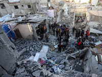 People stand on the rubble of a building after an Israeli strike in Nuseirat, Gaza Strip, on December 5, 2024, as the war between Israel and...