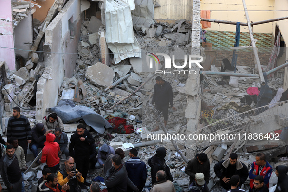 People stand on the rubble of a building after an Israeli strike in Nuseirat, Gaza Strip, on December 5, 2024, as the war between Israel and...