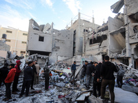 People stand on the rubble of a building after an Israeli strike in Nuseirat, Gaza Strip, on December 5, 2024, as the war between Israel and...