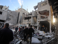 People stand on the rubble of a building after an Israeli strike in Nuseirat, Gaza Strip, on December 5, 2024, as the war between Israel and...