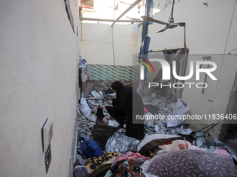 People stand on the rubble of a building after an Israeli strike in Nuseirat, Gaza Strip, on December 5, 2024, as the war between Israel and...