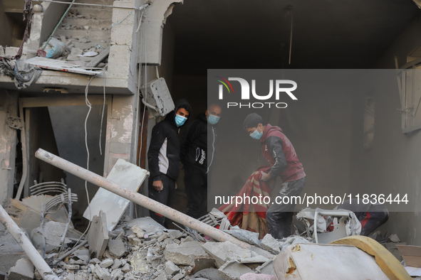 People stand on the rubble of a building after an Israeli strike in Nuseirat, Gaza Strip, on December 5, 2024, as the war between Israel and...