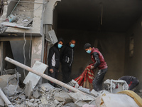 People stand on the rubble of a building after an Israeli strike in Nuseirat, Gaza Strip, on December 5, 2024, as the war between Israel and...